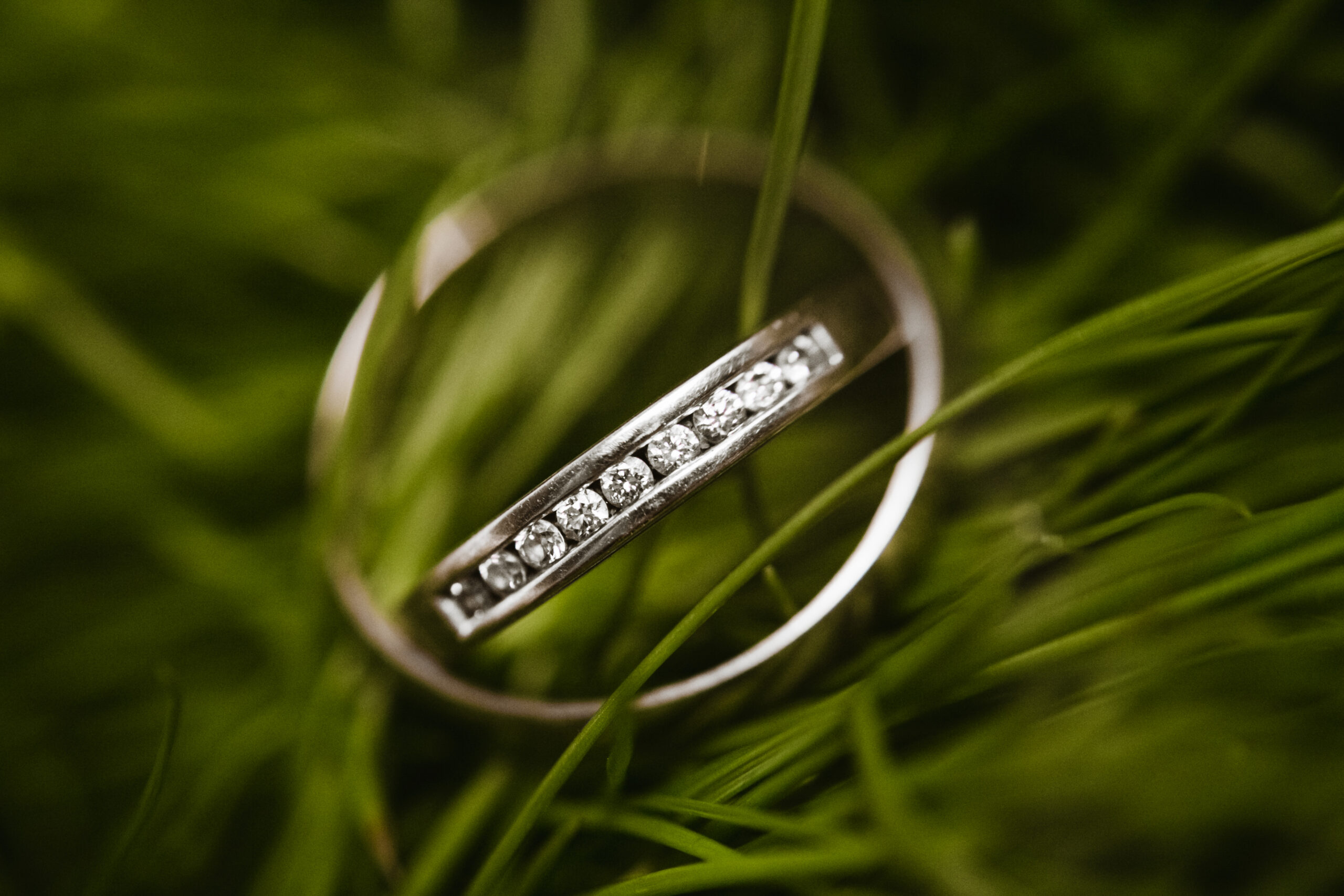 Beautiful bridal wedding rings lie one by one in the grass